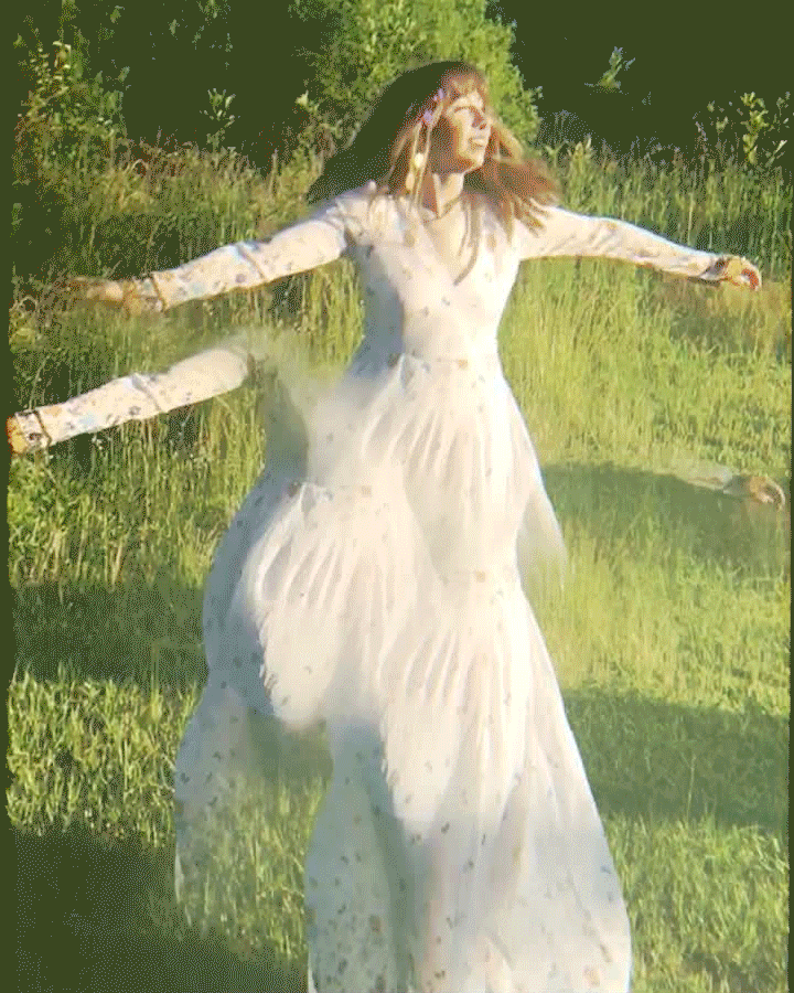 vintage gif of woman twirling outside wearing white dress