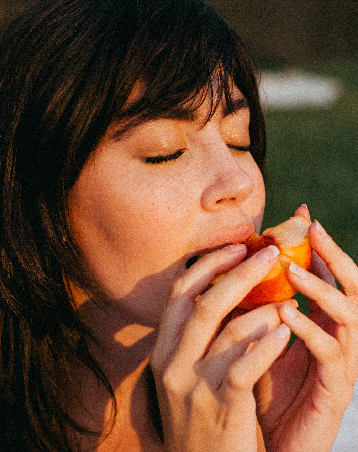 closeup of girl eating peach